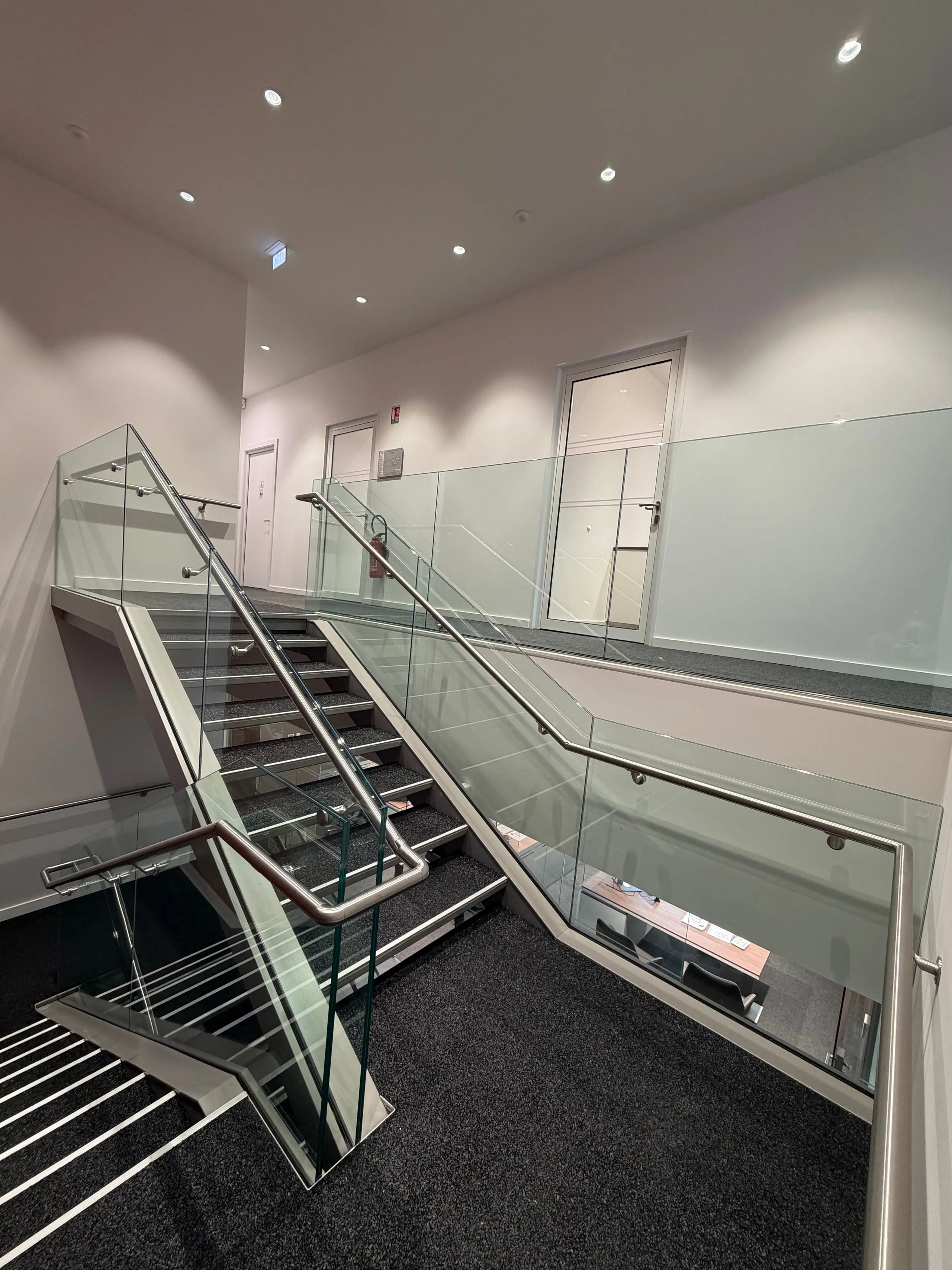 Garde-corps vitré le long d’un escalier intérieur au Centre Porsche Strasbourg
